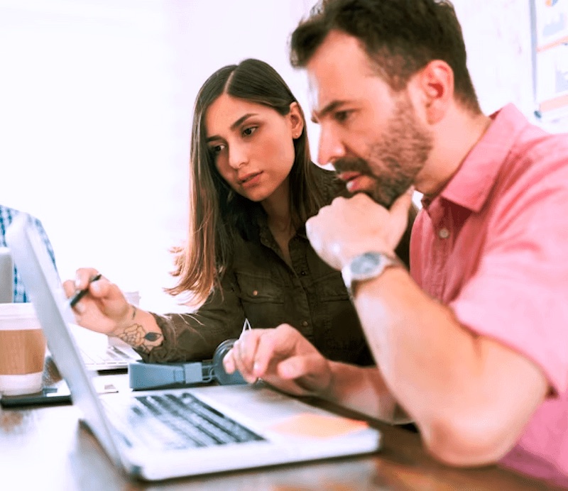 Profesionales colaborando frente a un computador